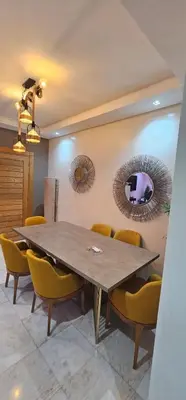a dining room with a table and yellow chairs at Jnane californie in Casablanca