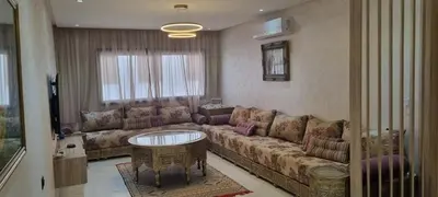a living room with a couch and a table at Luxueux Appartement Familial à Harhoura, Rabat Piscine & Plage à pied in Temara