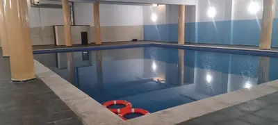 a swimming pool with a red object in the water at Luxueux Appartement Familial à Harhoura, Rabat Piscine & Plage à pied in Temara