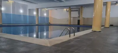 a swimming pool in a room with columns and water at Luxueux Appartement Familial à Harhoura, Rabat Piscine & Plage à pied in Temara