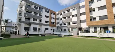 a courtyard of an apartment building with a green lawn at Luxueux Appartement Familial à Harhoura, Rabat Piscine & Plage à pied in Temara