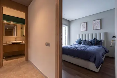 a bedroom with a king sized bed and a bathroom at Studio 1BR Near CFC - 5 Stars Experience in LʼOasis