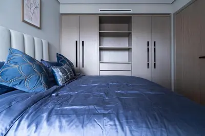 a bedroom with a blue bed with white cabinets at Studio 1BR Near CFC - 5 Stars Experience in LʼOasis