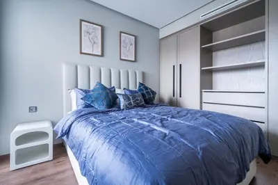 a bedroom with a blue bed and a white closet at Studio 1BR Near CFC - 5 Stars Experience in LʼOasis