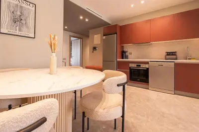 a kitchen with a table and chairs in a room at Studio 1BR Near CFC - 5 Stars Experience in LʼOasis