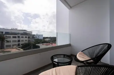 a balcony with two chairs and a large window at Studio 1BR Near CFC - 5 Stars Experience in LʼOasis