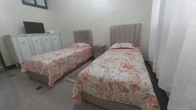 a bedroom with two beds and a television in it at Appartement Meublé avec Parking Gratuit, Calme & Pratique à Casablanca in Aïn Sebaa