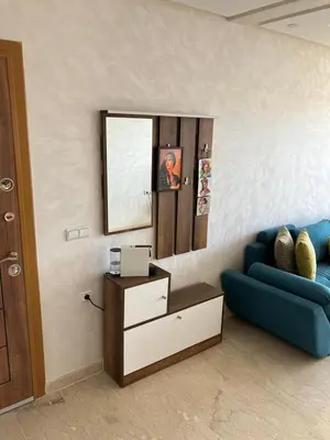 a living room with a blue couch and a mirror at Sunny 2-Bedroom Apartment with Pool for a Great Stay in Mohammedia