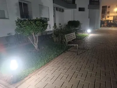 a bench sitting in the middle of a courtyard at night at Sunny 2-Bedroom Apartment with Pool for a Great Stay in Mohammedia