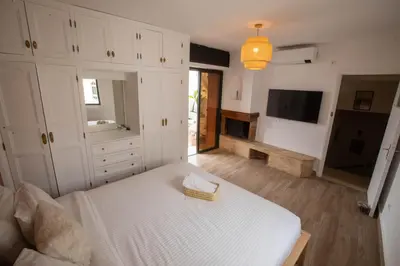 a bedroom with a white bed and a television at Duplex au centre de Rabat in Rabat