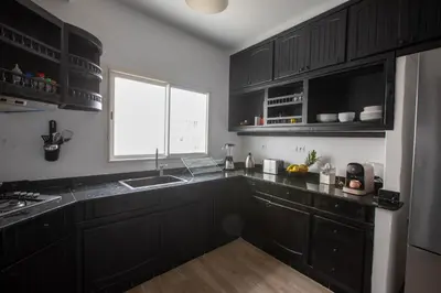 a kitchen with black cabinets and a sink and a window at Duplex au centre de Rabat in Rabat