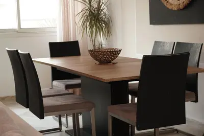a dining room with a wooden table and chairs at Cosy Loft - 2 Bedrooms & Parking - Agdal Center in Rabat