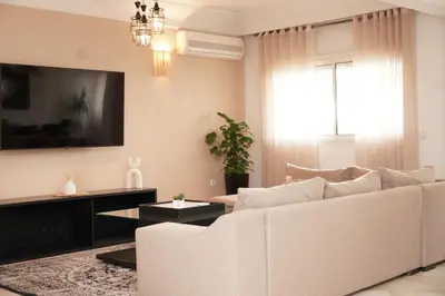 a living room with a white couch and a tv at Cosy Loft - 2 Bedrooms & Parking - Agdal Center in Rabat