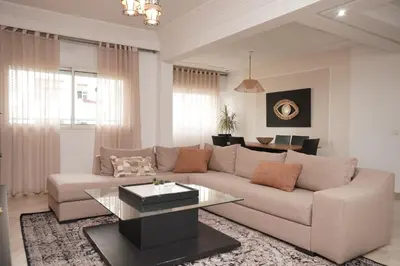 a living room with a couch and a table at Cosy Loft - 2 Bedrooms & Parking - Agdal Center in Rabat