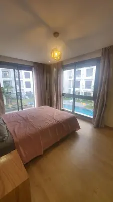 a bedroom with a bed and two large windows at Beautiful apartment 2 bedrooms living room aéroport mohamed 5 nouaceur Casablanca in Casablanca