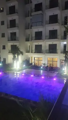 a swimming pool in front of a building at night at Beautiful apartment 2 bedrooms living room aéroport mohamed 5 nouaceur Casablanca in Casablanca