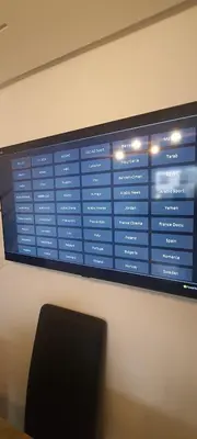 a projection screen on a wall with a black chair at Appartement avec Piscine à Tamaris, Confort, Vue Jardin et Plages à Proximité in Tamaris