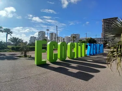 a large green sign with a city in the background at Très beau studio Océan Park in Aïn Harrouda