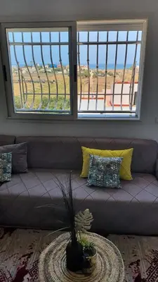 a couch in a living room with a large window at Ocean View Tamaris in Tamaris