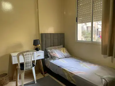 a bedroom with a bed and a desk with a chair at Bedroom for girls only in Casablanca
