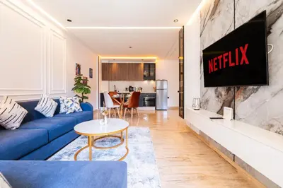 a living room with a blue couch and a tv on a wall at Chic blue studio au cœur deCasablanca in Casablanca
