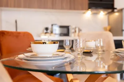 a glass table with a bowl and plates and wine glasses at Chic blue studio au cœur deCasablanca in Casablanca