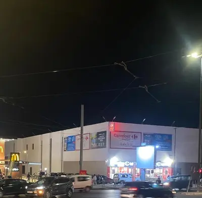 a building with cars parked in a parking lot at night at Appartement Spacieux & Moderne, 2 min Gare, 10 min Plage, Parking Gratuit in Casablanca