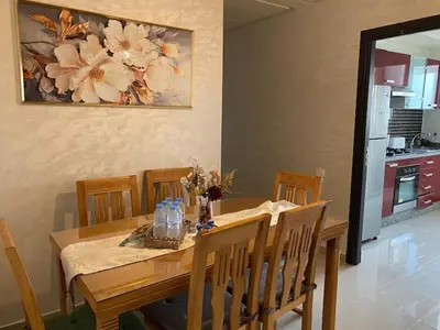a dining room table and chairs with a table and a painting at Appartement Spacieux & Moderne, 2 min Gare, 10 min Plage, Parking Gratuit in Casablanca