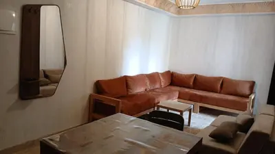 a living room with a brown couch and a table at Macha allah in Bouznika