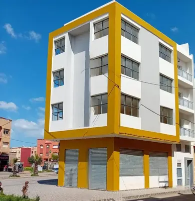 a white and yellow building on a street at Studio Marzouga in Deroua