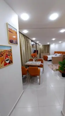 a living room with a table and orange chairs at Studio Marzouga in Deroua