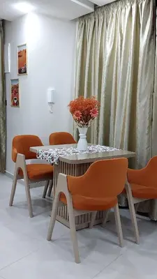 a table with orange chairs and a vase with flowers on it at Studio Marzouga in Deroua