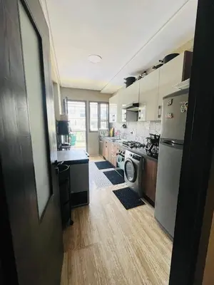 a kitchen with a stove and a washer and dryer at Appartement à louer in Nouaceur