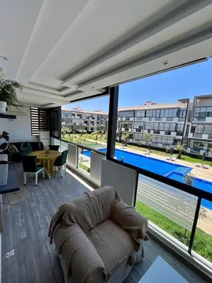 a living room with a couch in front of a large window at Appartement à louer in Nouaceur
