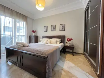 a bedroom with a large bed and a large window at Central Studio Casablanca in Casablanca