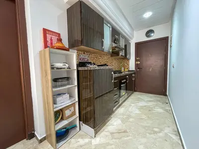 a kitchen with brown cabinets and a counter top at Central Studio Casablanca in Casablanca