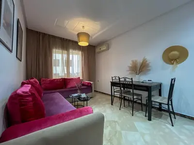 a living room with a red couch and a table at Central Studio Casablanca in Casablanca