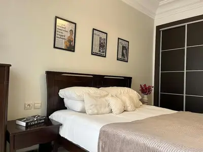 a bedroom with a bed with white sheets and pictures on the wall at Central Studio Casablanca in Casablanca