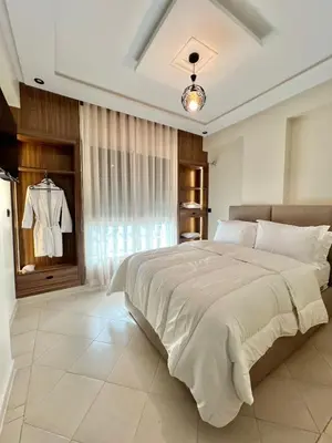 a bedroom with a large white bed and a window at Appartement élégant avec vue imprenable sur la corniche de Casablanca in Casablanca