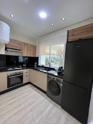 a kitchen with a black refrigerator and a dishwasher at Appartement élégant avec vue imprenable sur la corniche de Casablanca in Casablanca
