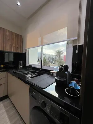 a kitchen with a stove and a sink and a window at Appartement élégant avec vue imprenable sur la corniche de Casablanca in Casablanca