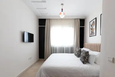 a bedroom with a white bed and a window at Appartement Luxueux pour Famille - Quartier Abdelmoumen in Casablanca