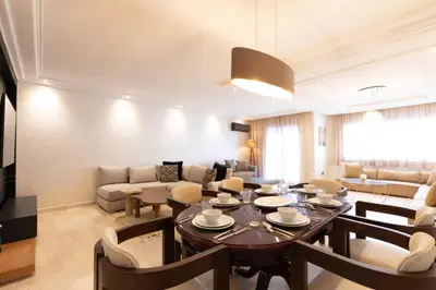 a living room with a dining table and a couch at Appartement Luxueux pour Famille - Quartier Abdelmoumen in Casablanca