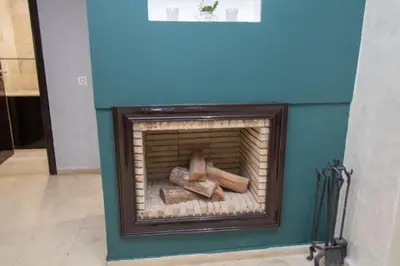 a fireplace with logs in it with a blue wall at Mamounia Horizon in Casablanca