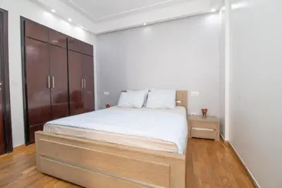 a bedroom with a large bed and a wooden cabinet at Mamounia Horizon in Casablanca