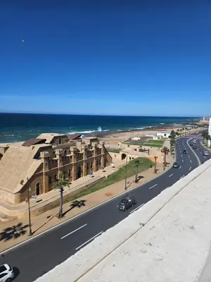 a view of a road with a building and the ocean at Apartamento Bonito in Rabat
