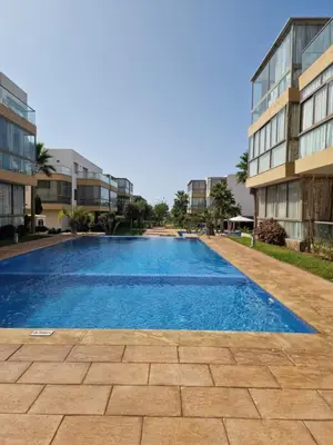 an empty swimming pool in front of a building at Résidence blue beach Sidi rahal in Sidi Rahal