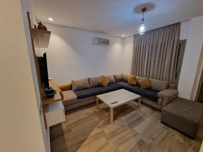 a living room with a couch and a table at Résidence blue beach Sidi rahal in Sidi Rahal