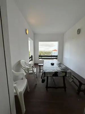 a room with a table and chairs and a window at Beach flat with pool at Al Mansouria in O Ben Slimane