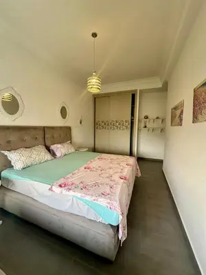 a bedroom with a bed and a chandelier at Appartement Blanca Beach in Sidi Rahal
